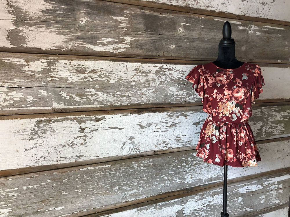 Maroon floral top displayed on a mannequin