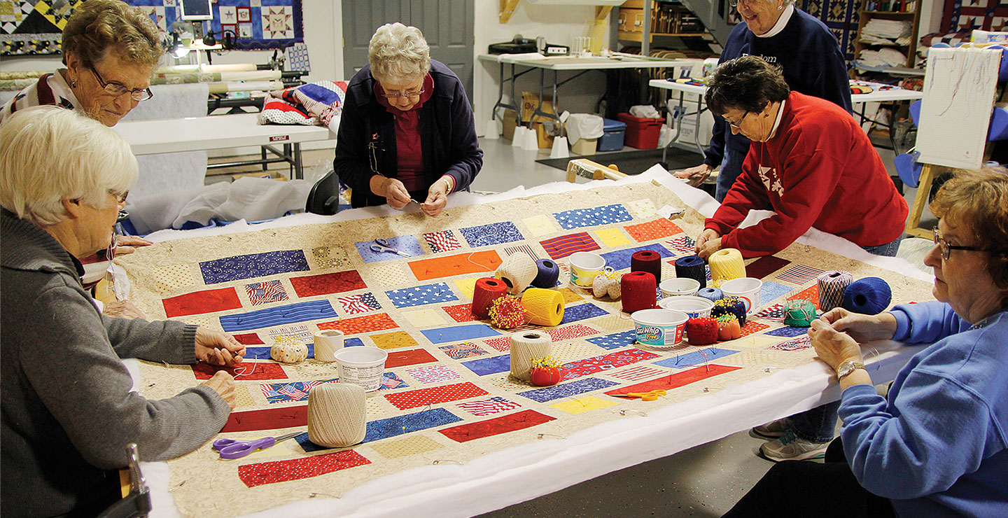 Elderly women working together on a quilt