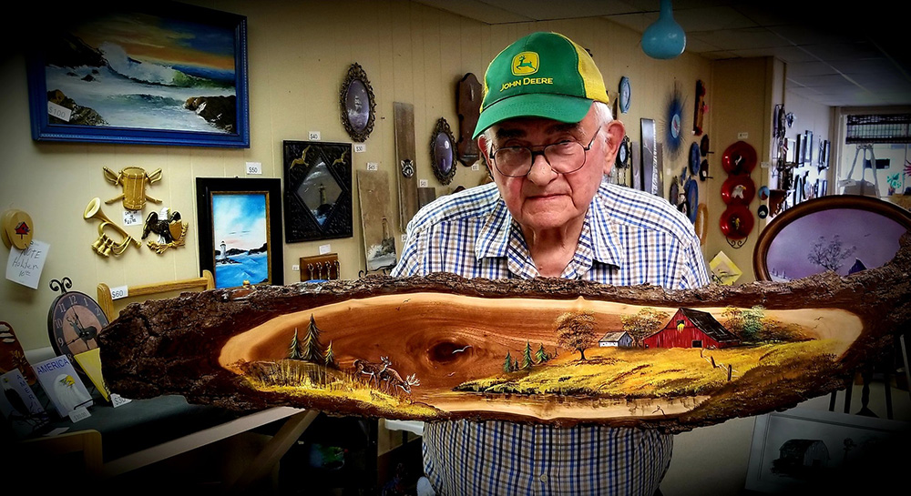 Man holds wooden slab with oil painting