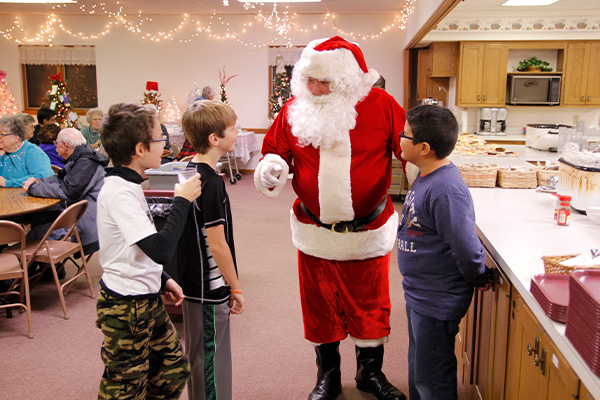 Three young boys talking with Santa