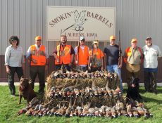 Hunters and their dogs pose with pheasants they've hunted